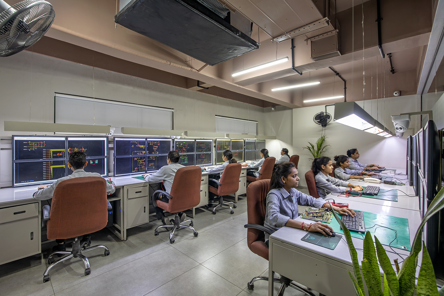 Synchronics Reverse Engineering Department — engineers tracing PCB schematics on multi-monitor workstations